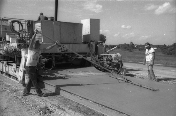 A cement finisher corrects surface imperfections left by the mechanical finisher during a resurfacing project on I90/94.