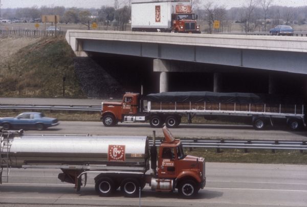 Trucks of the Central Wisconsin Transport Company of Wisconsin Rapids cross on the highway.