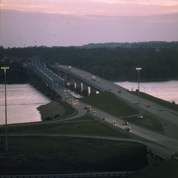 A view of the St. Croix River crossing at Hudson during the development of the Interstate Bridge. The old eastbound bridge seen here was built in 1951 while the west bound I-94 bridge was completed in 1971, about six years before this picture was taken. The old eastbound bridge was replaced in 1995.