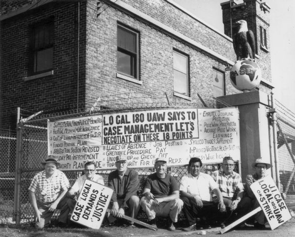 Striking members of the United Automobile Workers Union, Local 180 posed outside the tractor works in Racine with a banner indicating their demands.