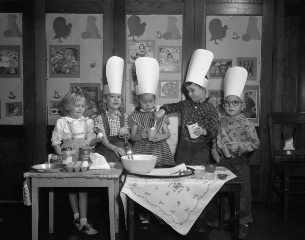 Kindergarteners at Dudgeon School in Mrs. Virginia Price's class make a pumpkin pie. Ready to add the egg is Nancy Olmstead, manning the beater is Julie Duckwitz, Marcia Kampen is measuring the pumpkin, Larry Elliott is spooning the pumpkin from the can and Mike Ivens is measuring the milk.