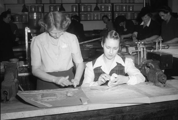 Every Friday afternoon 32 Cub Scout Den Mothers meet at the vocational school to learn crafts that they will teach to Cub Scouts. Mrs. Ted (Mildred) Field, left, and Mrs. G.E. (Vera) Cnare, right, are trying their hand at clay modeling