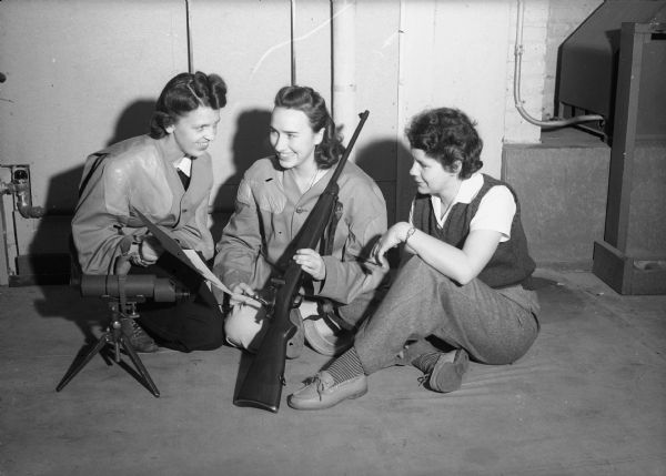 Three women receiving weapons training during World War II. Women are receiving training on the handling of a rifle.