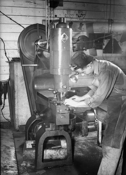 Man operating a drill press at Madison-Kipp Corporation, 201 Waubesa Street, producing war materiel during World War II.