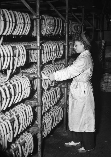 Female employee inspecting the quality of "Yellow Band" weiners at Oscar Mayer plant, 910 Mayer Avenue.