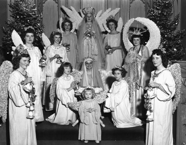 Christmas Pageant at Zion Lutheran Church. The angels are, left to right: Arlene Jenkins, Mary Sachtjen, Elsa Splett, Shirley Schumann, Joanne Groff, Joan Scheiwe, Dorothy Schultz, and Mitzi Schultz. Mary was portrayed by Alberta Smith. At the manger are Rochelle Dommershausen, Shirle Ann Becker, and Carole Schrotz.
