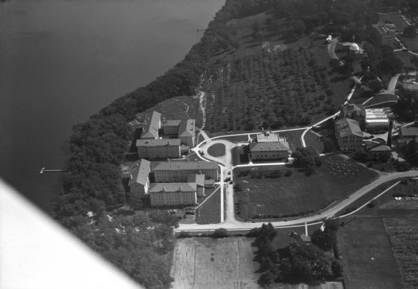 Aerial view of the University of Wisconsin-Madison, lakeshore dormitories, Adams Hall and Tripp Hall, also known as Van Hise Dormitories. Buildings included a refectory or cafeteria, (now called Carson Gulley Commons), King Hall, Washburn Observatory, the Home Economics building, the Dean of the College of Agriculture's residence, and the Lake Mendota shoreline.