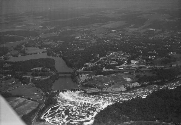 Aerial view of the town of Wisconsin Dells, the dam on the Wisconsin River, and the generating plant. The town of Wisconsin Dells was known as Kilbourn City until 1931.