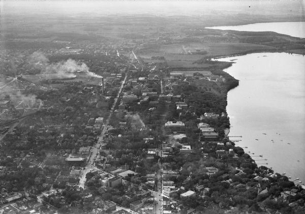 Aerial view of the University of Wisconsin-Madison campus, the State Historical Society of Wisconsin building, Lake Mendota, residential areas and the surrounding countryside.