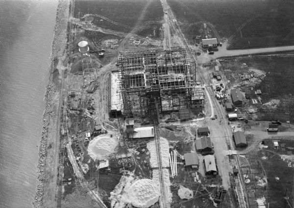 Aerial view of the construction of the Wisconsin Power and Light Company power plant on the shore of Lake Michigan.