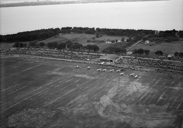 Aerial view of biplanes at the Pennco Field (Royal Airport), probably for an air show.  Lake Monona is in the background.