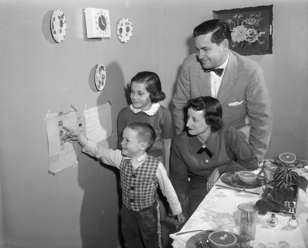Julius and Mary Sparkman and their children Melvin and Pamela looking at a chart showing efforts to be a peacemaker.  The Sparkmans were the directors of the Character Research Project, a national inter-denominational movement aimed at developing Christian character through close cooperation between church and family.