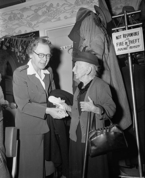 Lt. Col. Frieda Nolte, officer in charge of the Madison post, welcomes Jenny Frothingham to a Thanksgiving dinner served by the Volunteers of America to 56 members of its Sunset Club.