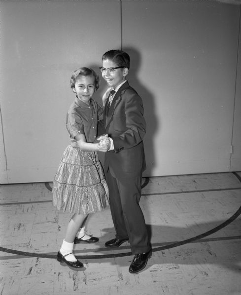 A young boy and girl dancing at the Cherokee Heights School dance party.