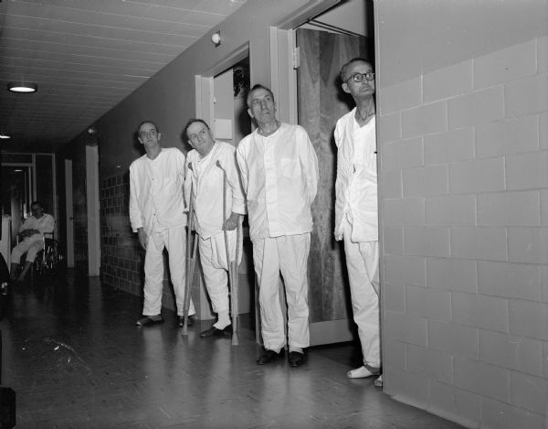 Male patients at the Veterans Hospital waiting in a hall to meet cartoonist Walt Kelly while he was visiting on a book tour.