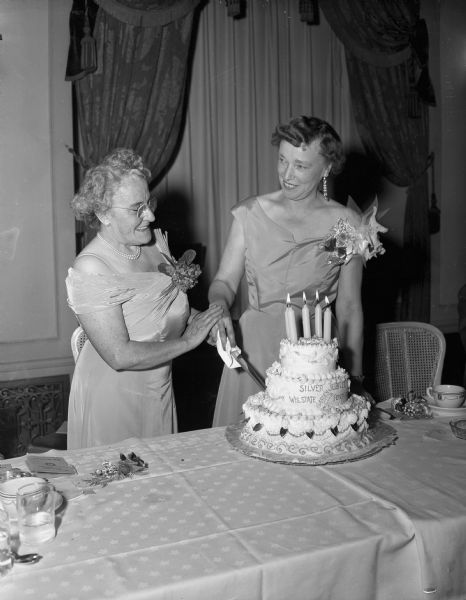 Margaret E. Garnett (Mrs. A.C.), of Madison, program chair of the convention, and Mrs. Linus Boehm of West Salem, president of the state federation, cutting a tiered birthday cake at the Silver Jubilee banquet of the Wisconsin Garden Club Federation at the Hotel Loraine.