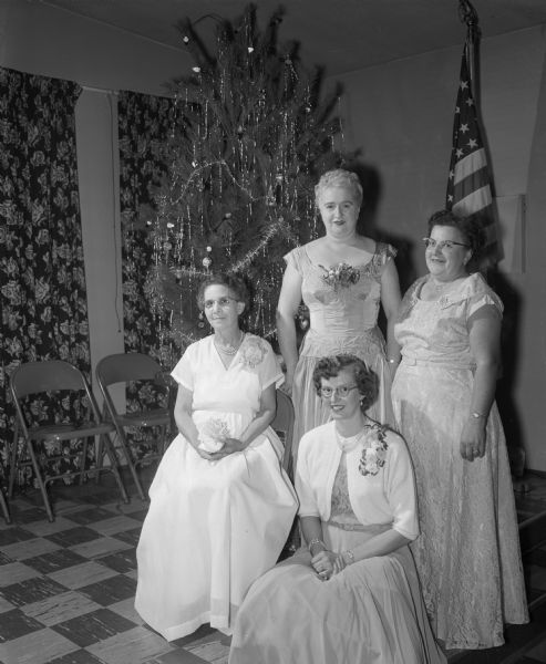 Four women in front of a Christmas tree at the Moose Club Christmas party.