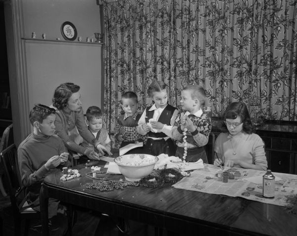 Mrs. Marie Shrout, 1102 Grant Street, preparing Christmas tree decorations with her children, Jim, 13, Patrick, 3, Douglas, 4, Susan, 9, Michael, 7, and Stacy, 12.