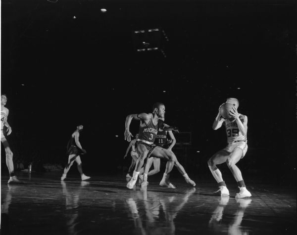 A Wisconsin baskeetball player attempts to pass the ball during a game between the University of Wisconsin and the University of Michigan.