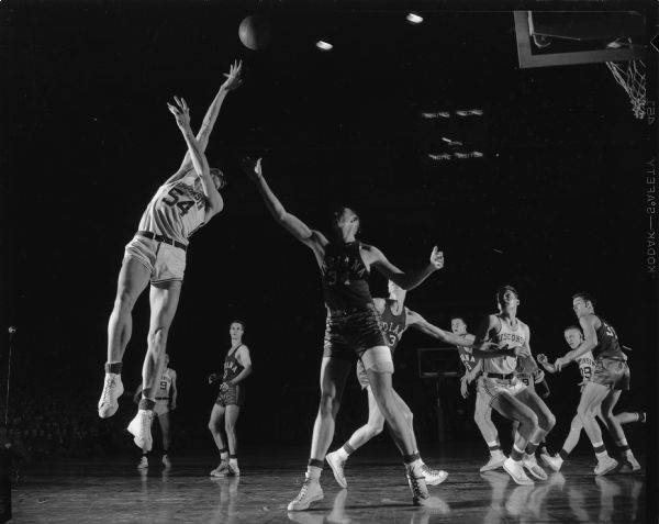 Wisconsin player number 54 attempts to make a basket at a University of Wisconsin vs. University of Indiana basketball game.