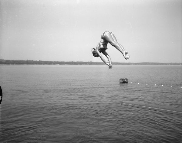 Tia Nelson, 11, daughter of Mr. and Mrs. Russell Nelson, 3010 Oxford Road, dives into Lake Mendota. She was one of Madison's most outstanding young swimmers.