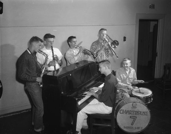 Members of the Wisconsin High School band, named the Chartreuse Seven Band, include Laird Marshall, piano, John Taylor, drummer, Charles Thompson, William Gandt, David Hamel, and Peter Hoffland, shown with their instruments. The band plays for school and church affairs.