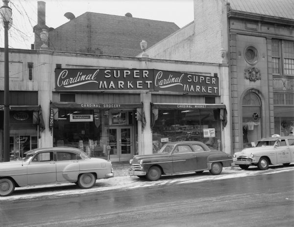 Cardinal Super Market, 120 North Fairchild Street. Automobiles are parked along the curb in front. The building on the right is Kessenich's, Inc.