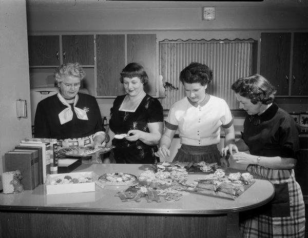 Members of the Nakoma Welfare League making cookies for the annual young people's party. Pictured left to right: Kathleen Clark, Esther Poehling, Merla DeGolier, and Lenore Bainbridge.