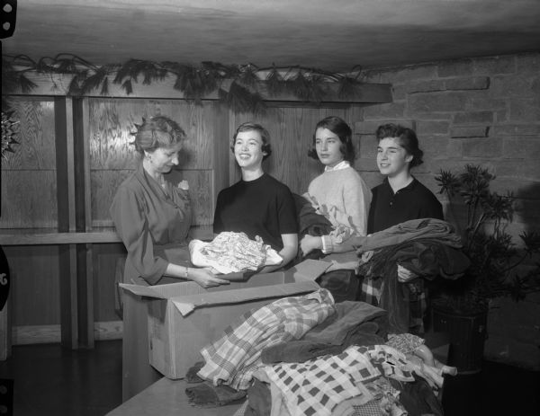 Members of Tri-Hi Sorority and members of the First Unitarian Society packing clothing for Hungarian relief. (L to R), Mrs. Elnar Haugen, Mary Ellen Lathers, Mimi Hastings, and Barbara Lease.