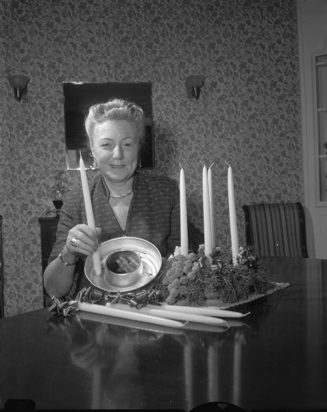 Mrs. Fred Chamberlin, 3475 West Belt Line, demonstrating the preparation and use of a Christmas Advent wreath at the Catholic Information Center, 435 State Street.