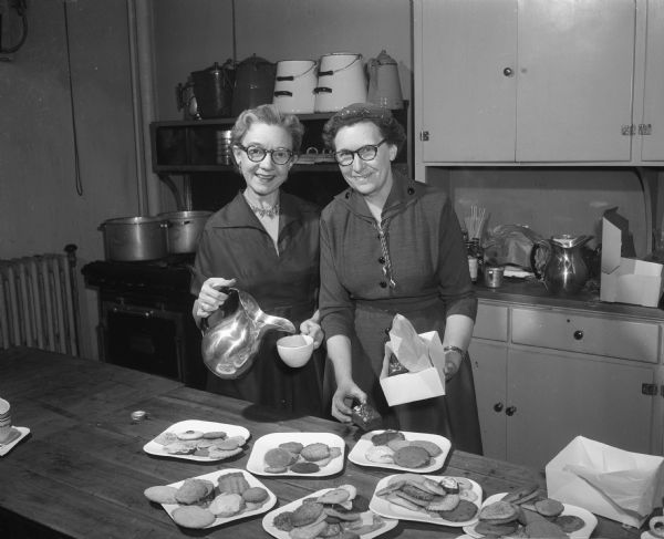 Estah Cummings and Evelyn Milliff, members of the Ways and Means Committee of the Madison Business and Professional Women's Club, in the kitchen preparing food for the benefit card party for the club's scholarship fund.