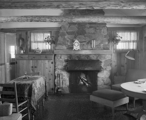 Family room with stone fireplace in remodeled log cottage called "Winwood," owned by Mr. and Mrs. Winfred Guenther, in the Town of Verona.