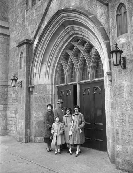 Fred and Velma DelliQuadri and their three daughters, Geri, Lyn, and Toni, enrollees in the Character Research Project, standing at the door of the First University Methodist Church.
