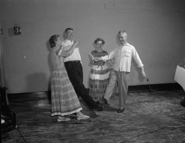 Harold & Marion Brandenburg and Erwin and Evelyn Gaumnitz participate in square dancing at the Nakoma Welfare League's Twelfth Night Party.  The program honored Walter W. Engelke, Nakoma School principal.