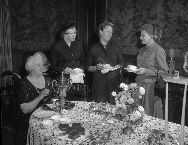 Ida Kittleson, Mary McCormick, Katherine Maurer, and Janet Pasch around a table at a tea given for the Madison Tuberculosis Association volunteer workers.