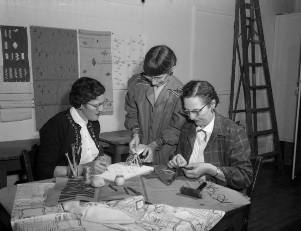 Lydia MacKenzie, Helen Burkhart, the instructor, and Lucille Harks participate in a class on textile handicrafts at the Madison Community Center.