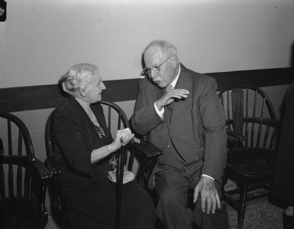 Dean Harry Russell, director of the Wisconsin Alumni Research Foundation and a veteran member of the Madison Literary Club, is shown talking with Katherine Jones (Mrs. Burr W. Jones), at the 75th anniversary party of the club.