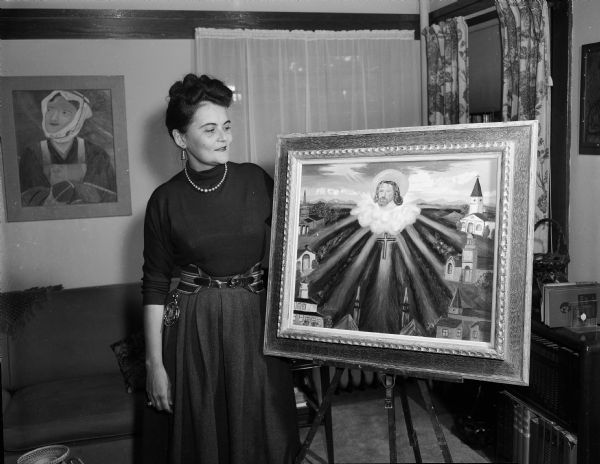 A woman stands beside a religious painting (of her own making?).