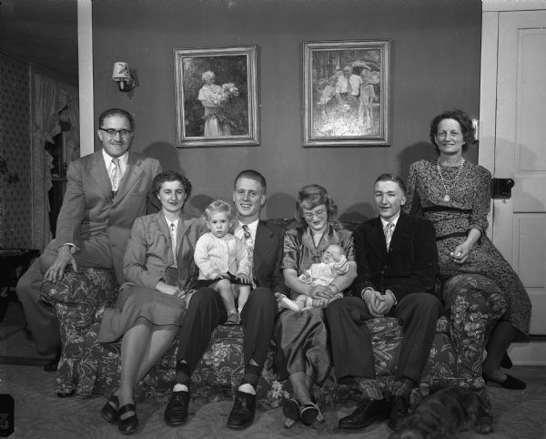 Family portrait of Mr. and Mrs. Russell Frost with their adult children and grandchildren seated on the sofa on Thanksgiving Day.