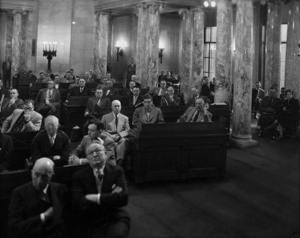 Group portrait of Wisconsin legislators sitting in the Assembly Chamber to hear Governor Kohler's message.