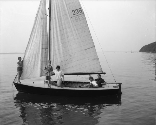 Jane and Kenneth White and their daughters, Sue, Kay, and Barbara, and the family dog, Perky, in their lightning class sailboat on Lake Mendota.