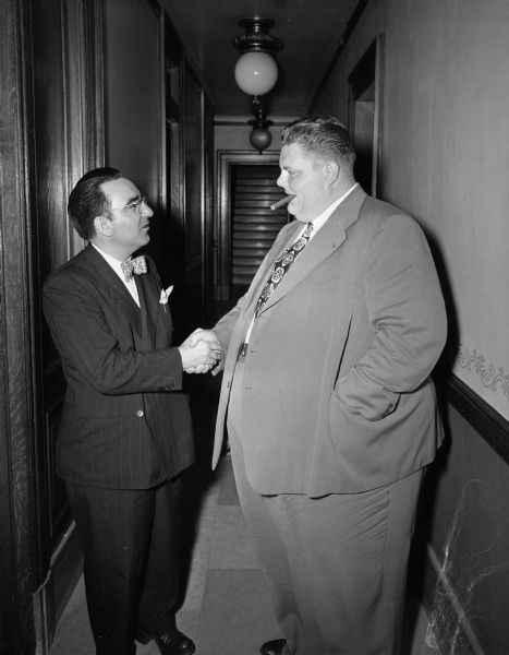 Senator John C. McBride (R-Milwaukee), and Senator Clifford W. "Tiny" Krueger (R-Merrill), perform a farewell handshake outside the Wisconsin senate chamber.
