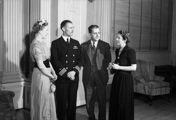 Commander Leslie K. and Isabelle Pollard with Professor Howard B. and Mrs. Doke at the University of Wisconsin University League dance reception at the Memorial Union. Commander Pollard is head of the Naval Radio Training School on the university campus. Mr. Doke is an assistant professor in the engineering school. Standing, left to right, are Mrs. Doke, Commander Pollard, Professor Doke, and Mrs. Pollard.