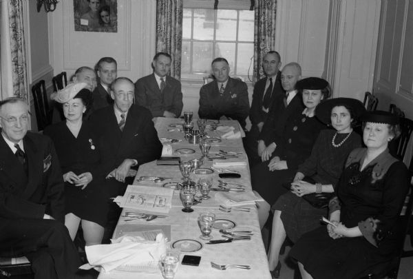 Red Cross War Fund Drive leaders sitting at a table discussing plans for war fund drive. Left to Right: James R. Law, June B. Wheeler, Louis Hirsig, Alden W. White, Dr. Harold C. Bradley, Arthur Towell, Roy Brecke, George Boese, Hobart H. Klezein, Ruby Taff, Edith Jens, Mary Martin.
