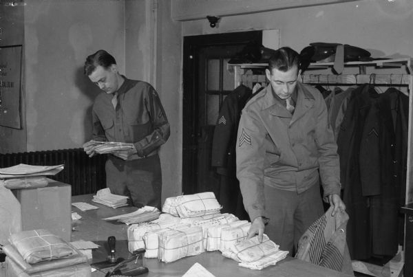 Private William Huneke and Sargeant Harold Gleaves checking in a stack of mail from soldiers and sailors at the fighting fronts of the world for the United States Armed Forces Institute (USAFI).