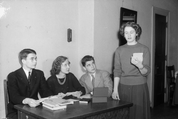 Members of the Wisconsin High School debate team preparing for the state tournament at the Wisconsin State Capitol. Left to right: Wayland Noland, Phyllis Crosby, David Beckwith, and Jane Nethercut.