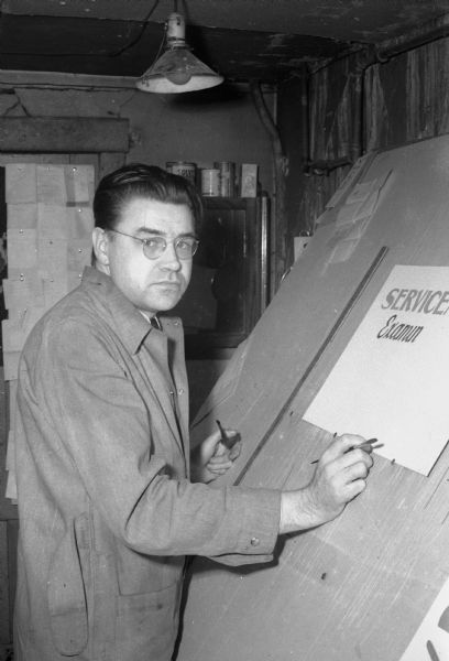 George I. Wallace, signmaker, making signs at his shop at 439 West Main Street. He wrote an editorial column for the newspaper, "A Layman's View of Religion Today."