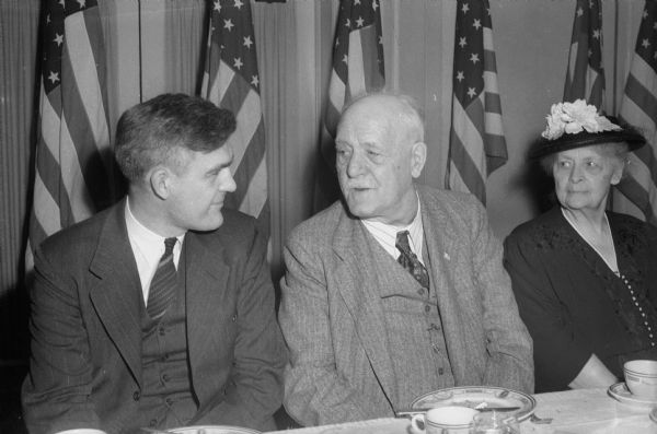 Acting Governor Goodland talking with United States Senator Joseph H. Ball (R-Minn.), at a luncheon for Republican Presidential candidate Harold E. Stassen. Governor Goodland's wife looks on from the right.