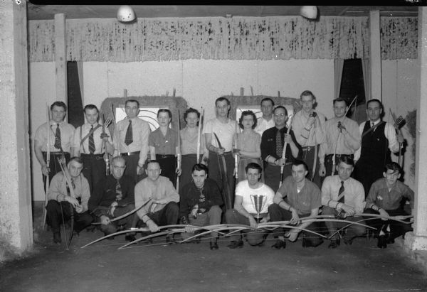 Members of the Madison Archery League, both men and women, with their bows.