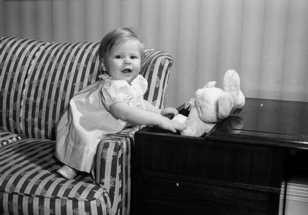 Whitney Mason Gould, daughter of Mr. and Mrs. Stevens Gould, 712 Rogers Street, with a stuffed rabbit illustrating traditional Easter gifts for children.